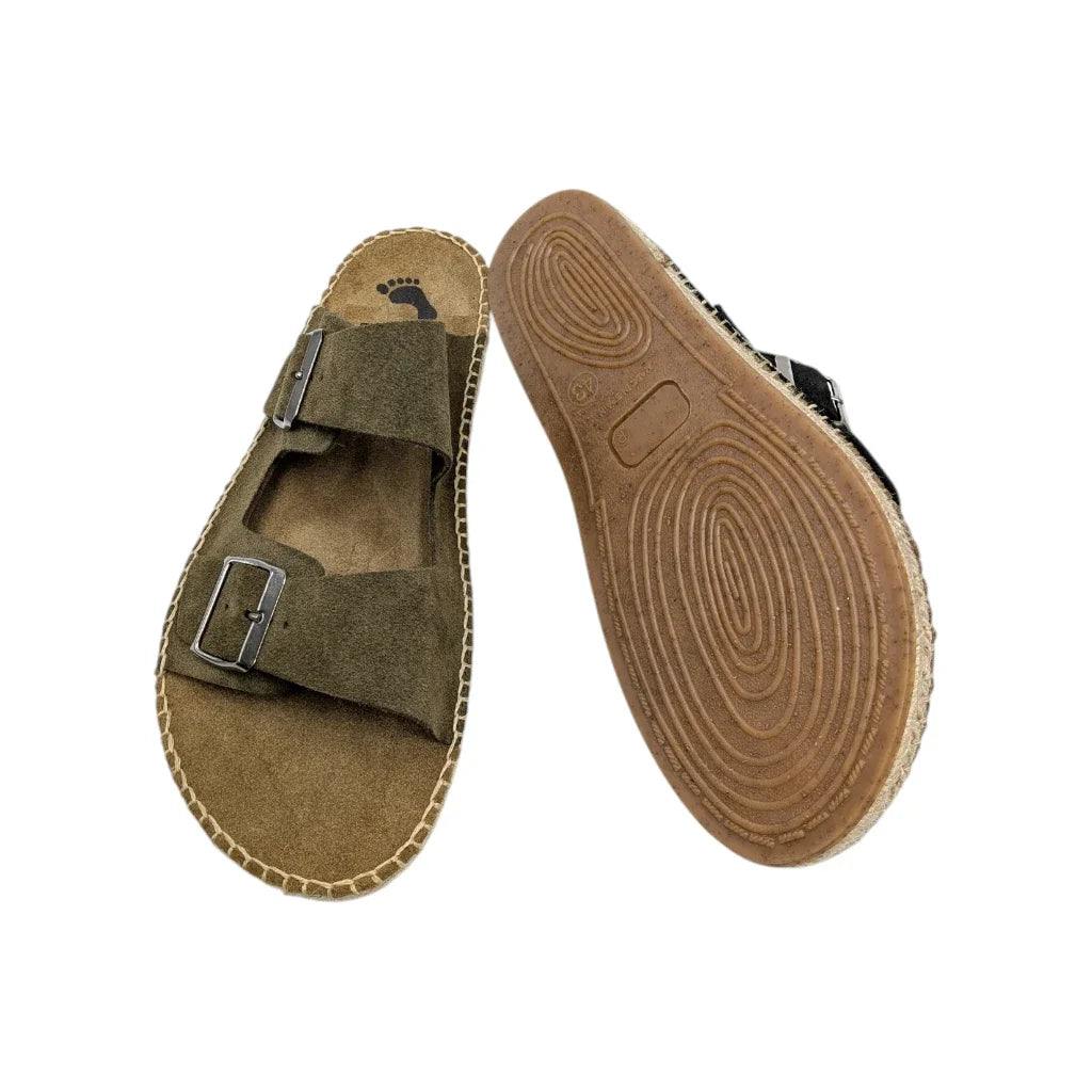 Primer plano de la suela de goma en un pie de la sandalia Salvi y la planta en el otro pie.