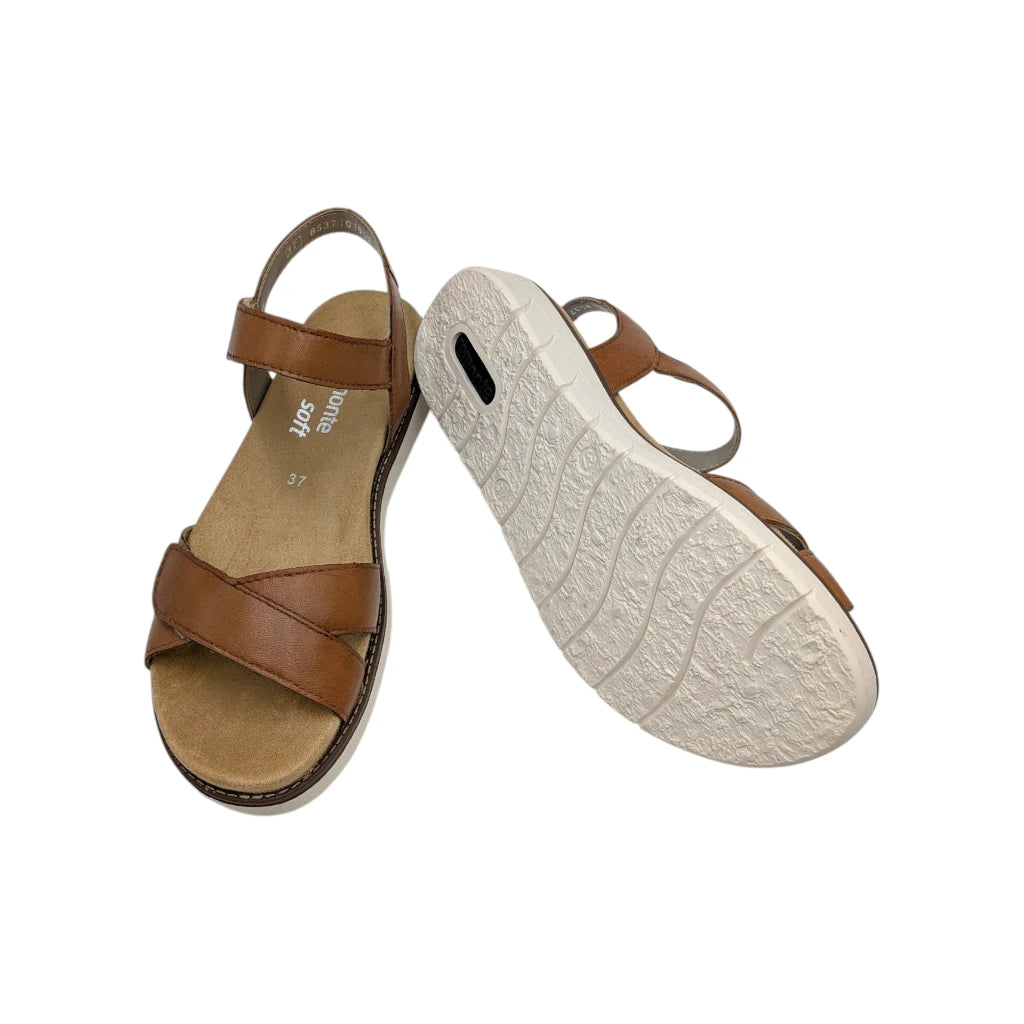 Vista de la suela de la sandalias para mujer con plataforma baja y diseño ergonómico en color marrón.