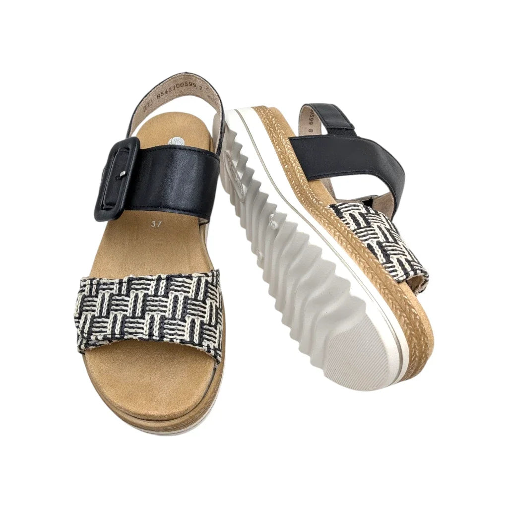 Primer plano de la suela con plataforma de la sandalia Remonte y el frente del otro pie.