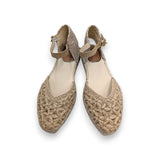 Primer plano del trenzado artesanal de rafia con forma de flores en la puntera de la sandalia.