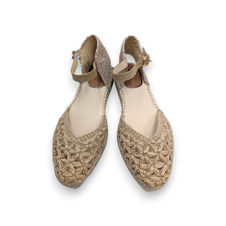 Primer plano del trenzado artesanal de rafia con forma de flores en la puntera de la sandalia.