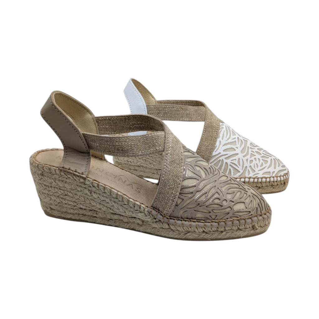 Alpargatas de cuña media de la marca Ramoncinas, color beige. Cuentan con puntera calada de diseño floral, tiras elásticas cruzadas sobre el empeine y suela de esparto trenzado con costura vista.