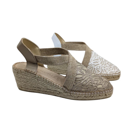 Alpargatas de cuña media de la marca Ramoncinas, color beige. Cuentan con puntera calada de diseño floral, tiras elásticas cruzadas sobre el empeine y suela de esparto trenzado con costura vista.