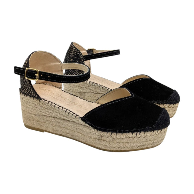 Alpargatas de cuña negras marca Ramoncinas con plataforma de esparto y cierre de pulsera sobre fondo blanco.