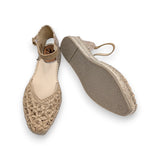 Vista posterior de la sandalia Salvi mostrando la suela  de un pie y el empeine trenzado en el otro.