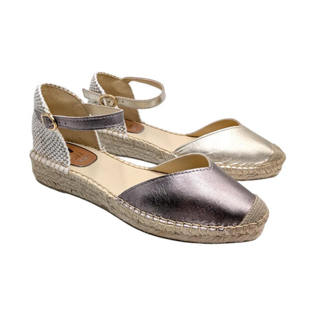 Vista lateral de alpargata metalizada color plomo con suela de esparto y cierre de hebilla.