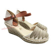 Sandalias de cuña tipo alpargata de lona natural con tira de tobillo y hebilla de piel color camel. Costuras decorativas en la puntera.