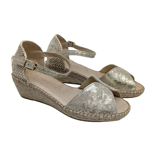 Sandalias de cuña Ramoncinas en piel metalizada dorada y suela de cáñamo sobre fondo blanco.