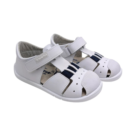 Sandalias infantiles Titanitos modelo Cristian en piel blanca con detalles azules y cierre de velcro.