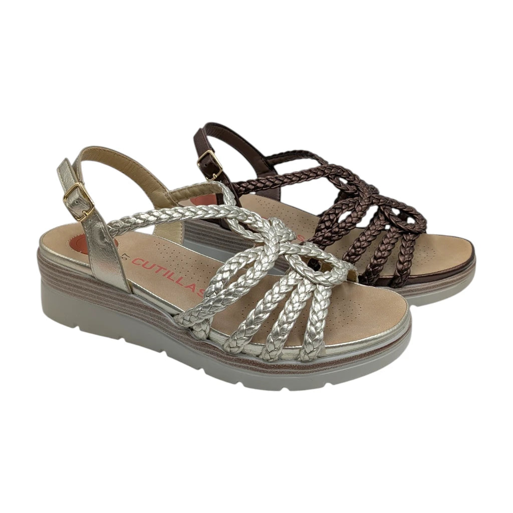 Sandalias de mujer Doctor Cutillas en color bronce y platino con diseño trenzado sobre fondo blanco.