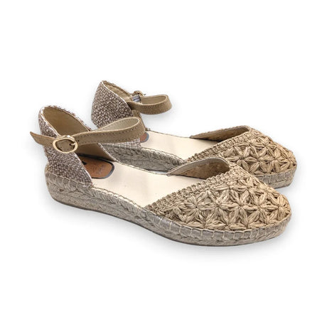 Sandalia Salvi de cáñamo y rafia color natural con detalle de puntera floral calada sobre fondo blanco.