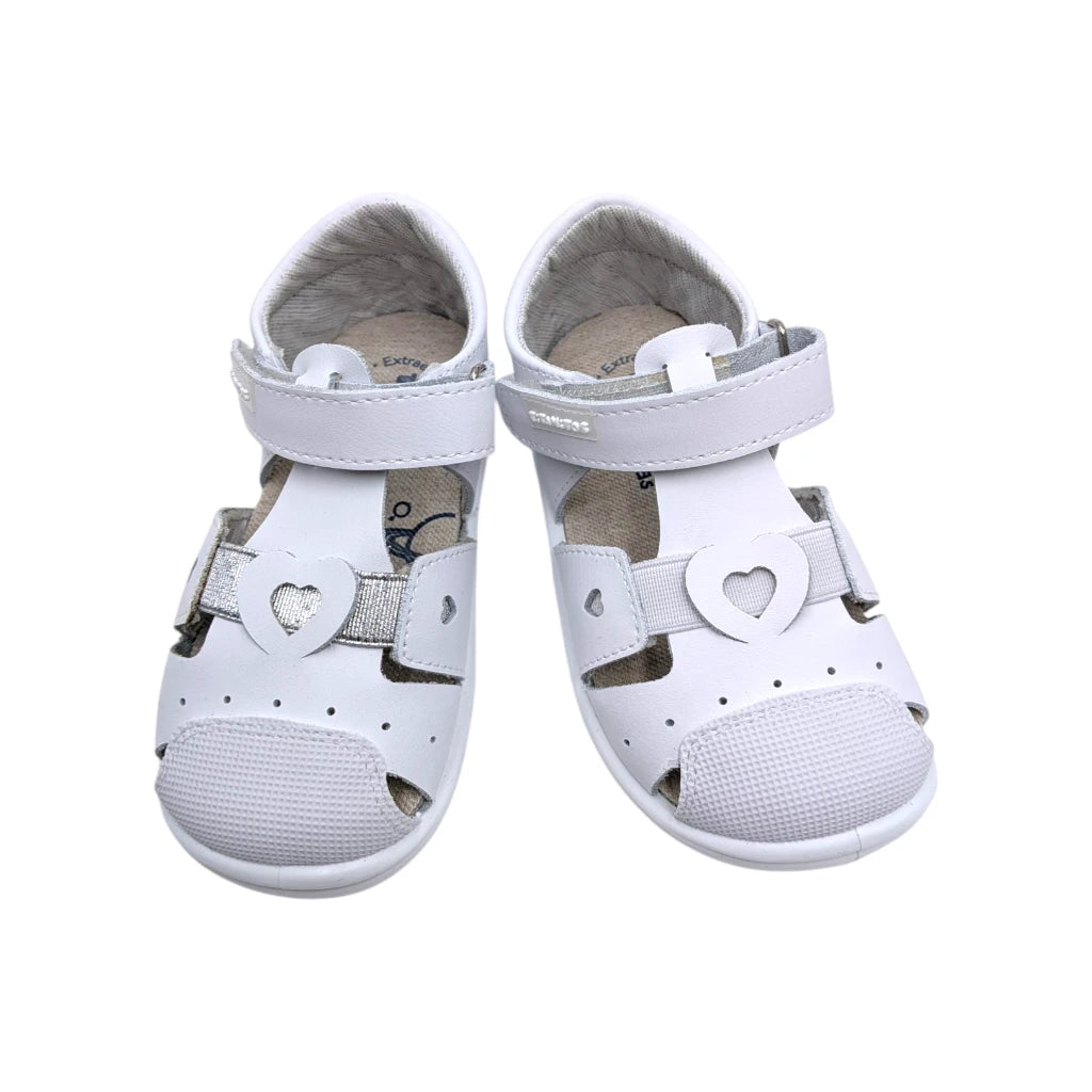 Primer plano de los corazones troquelados y la tira brillante de la sandalia Teresa.