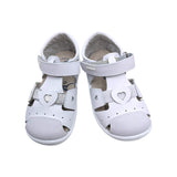 Primer plano de los corazones troquelados y la tira brillante de la sandalia Teresa.