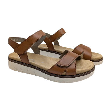 Vista lateral de sandalias de mujer en piel color cuero con suela blanca dentada.