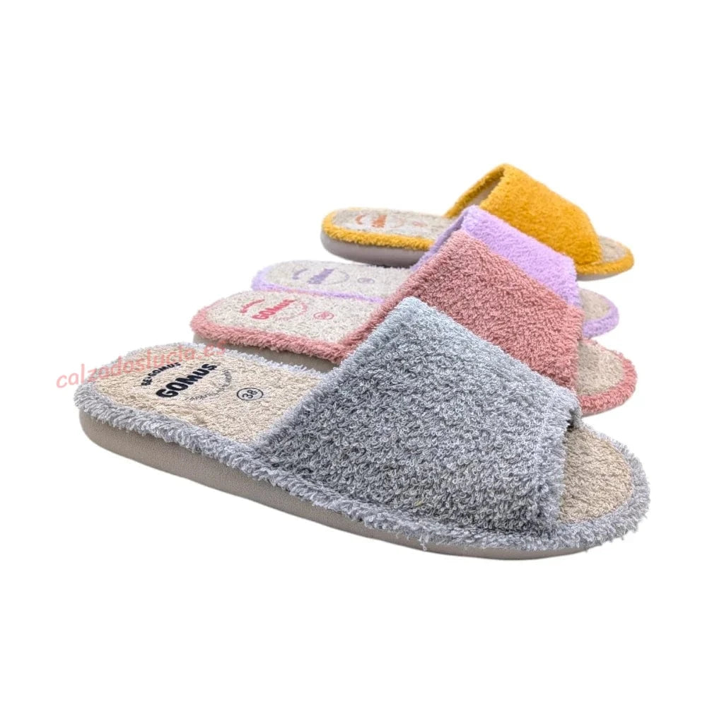 Cuatro zapatillas de rizo en colores gris, rosa, malva y yema, calzado cómodo de fabricación nacional para el descanso diario en verano.