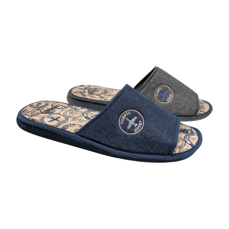 Detalle del bordado circular con un avión en la parte superior de la zapatilla Gomus.