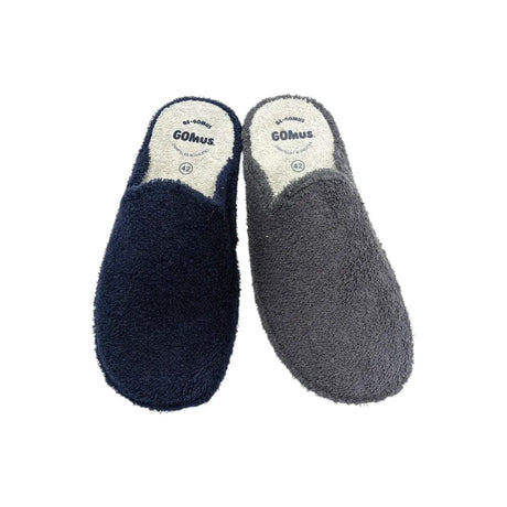 Primer plano de zapatillas Gomus masculinas de rizo color gris, mostrando la textura del tejido y el logotipo en la plantilla.