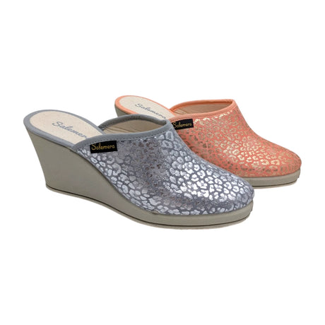 Zuecos de cuña alta Salemera en colores plata y coral con estampado animal print sobre fondo blanco.